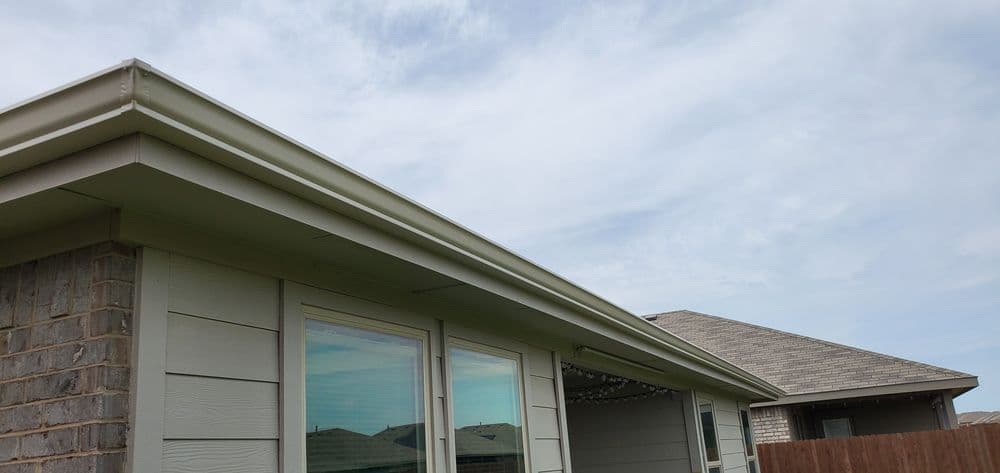 House exterior featuring a neatly finished roofline and cloud-filled sky.