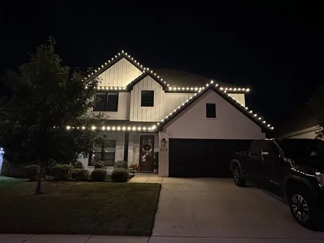 Permanent exterior lighting running the roofline of a home at night