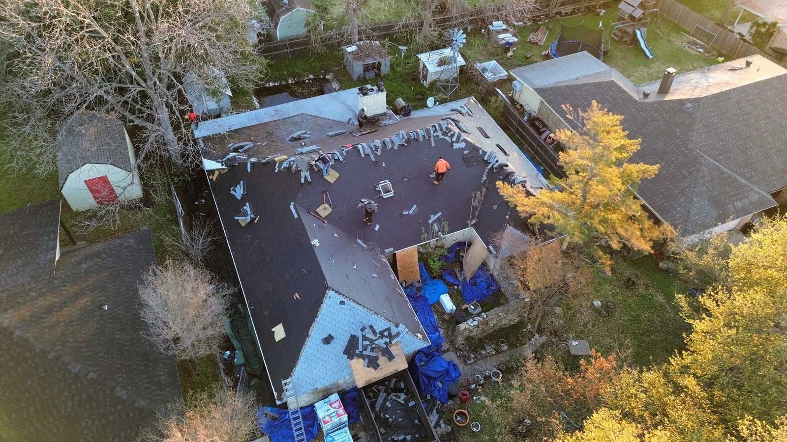 Crew working on a residential shingle roof in North Texas
