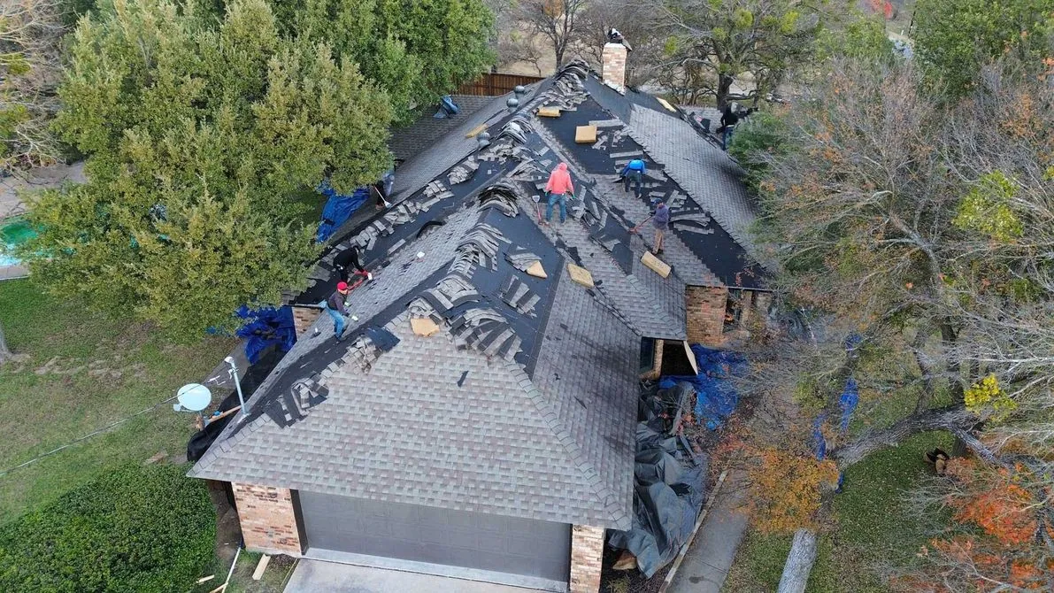 Crew working on a residential shingle roof in North Texas