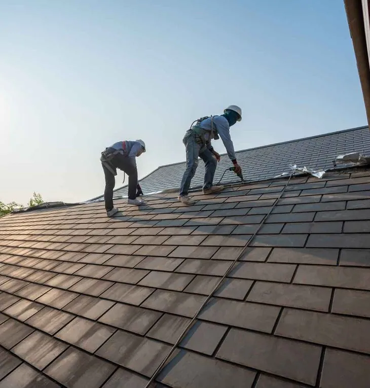 Crew working on a residential shingle roof in North Texas
